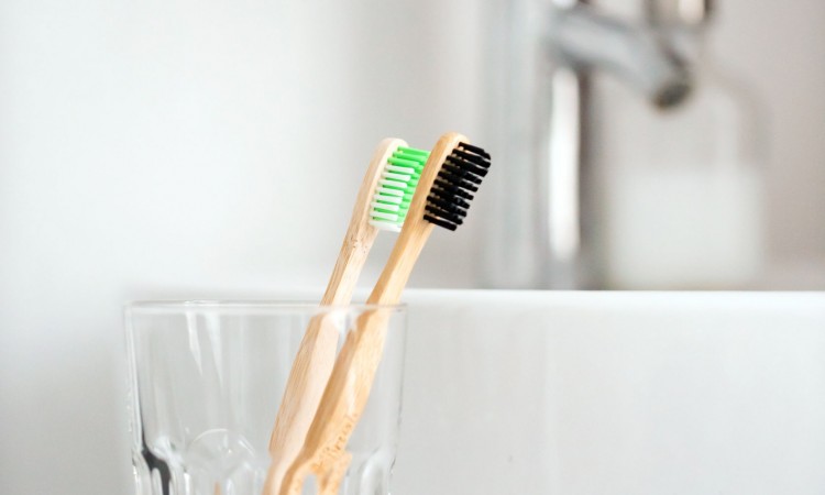 eco natural bamboo toothbrushes in glass. sustainable lifestyle concept. zero waste home. bathroom essentials, plastic free items