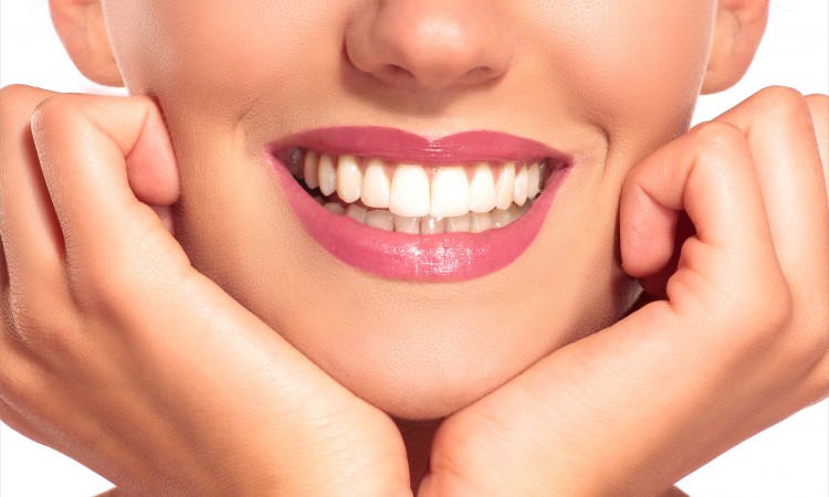 Closeup of smiling woman with perfect white teeth on white