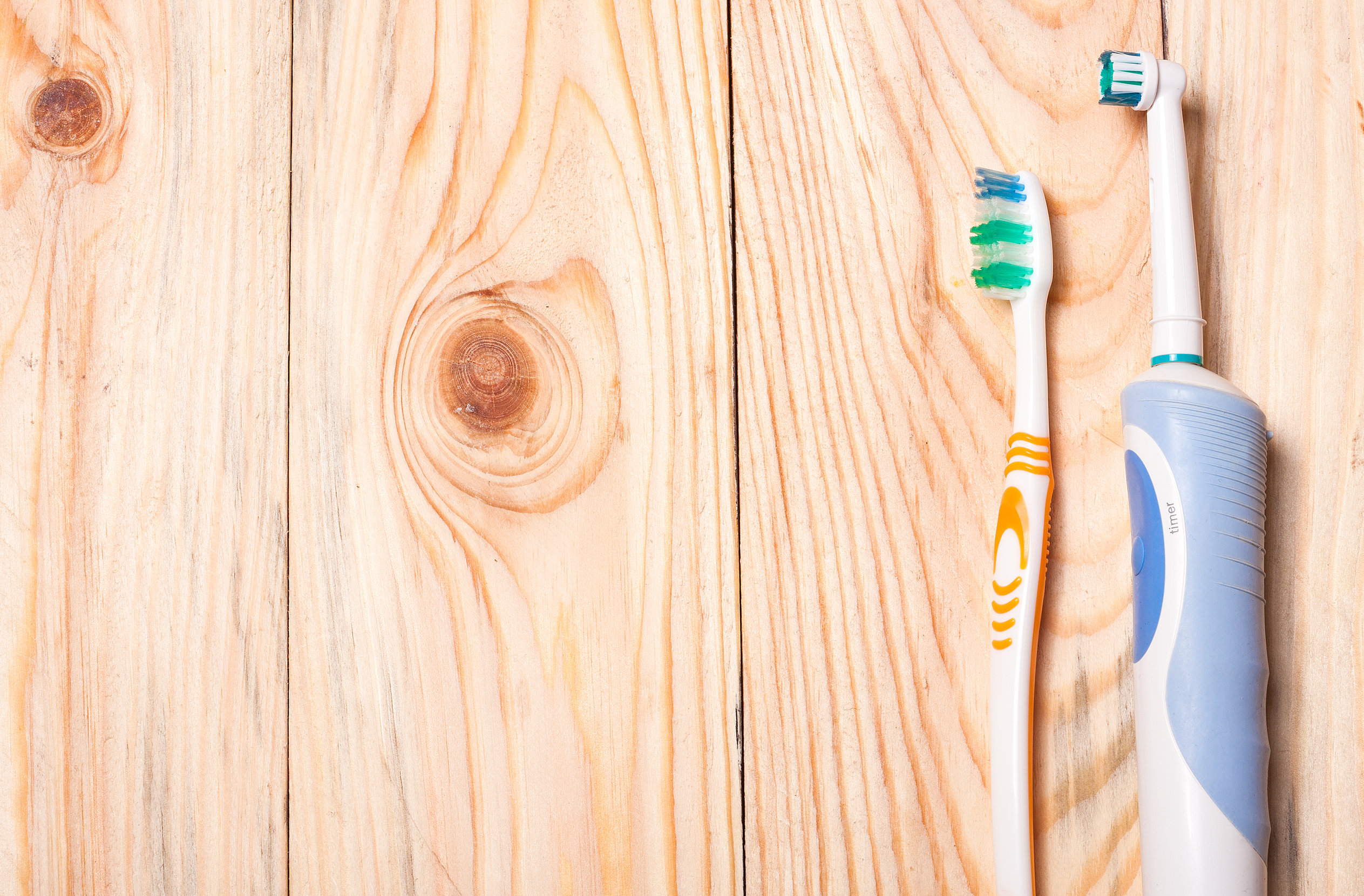 Electric Toothbrush on a light wooden background.